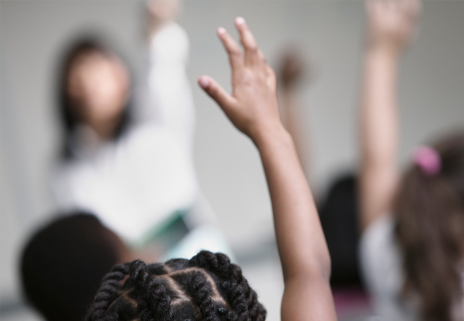 Children in school with raised hands